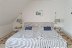 'Ein Schlafzimmer bietet ein Doppelbett (1,80 x 2,00 m) und wirkt heimelig.'