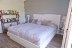 'Das Schlafzimmer im EG bietet ein Doppelbett (180 x 200 cm), einen kleinen Schreibtisch, sowie einen Ausgang in den Garten.'