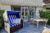 'Die Terrasse mit Strandkorb und Gartenmbeln ldt zum Verweilen ein.'