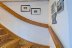 'Eine Treppe mit Handlauf fhrt ins Obergeschoss.'