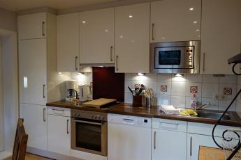 Die offene K��chenzeile mit Ceranfeld, Backofen, Geschirrsp��ler, K��hlschrank.